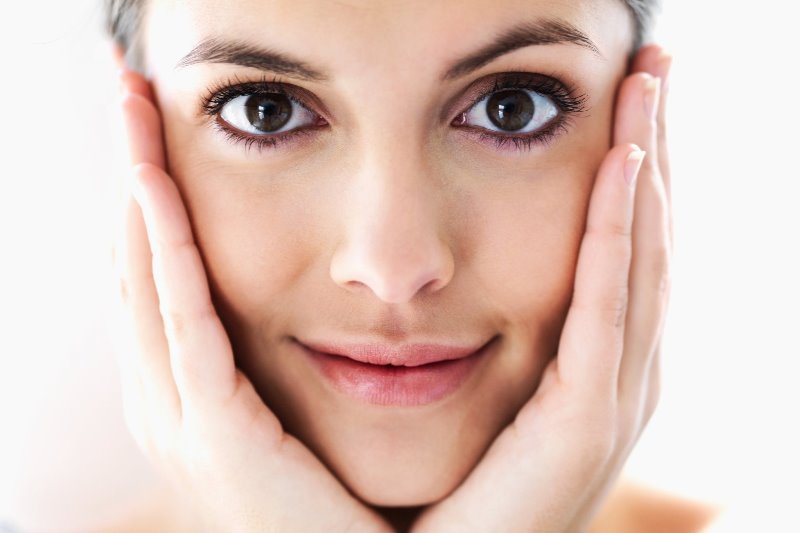 Женщина касается лица