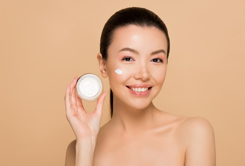 Девушка держит крем в руках