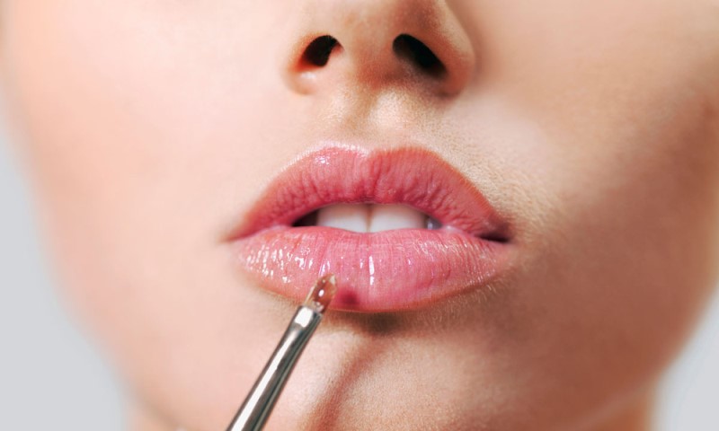 Наносится блеск для увеличения губ