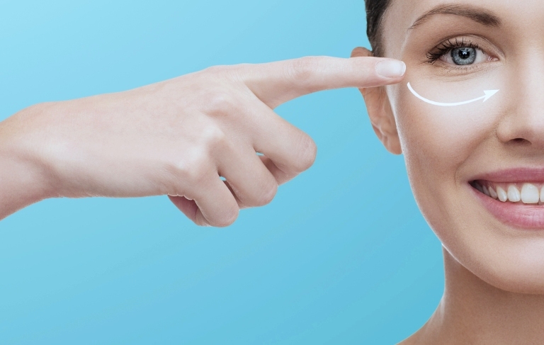 девушка показывает на область глаза