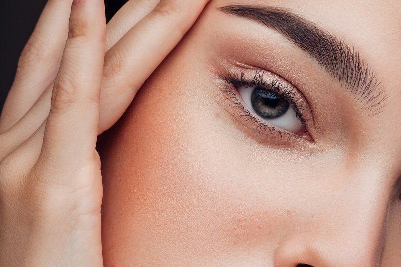 Девушка касается бровей