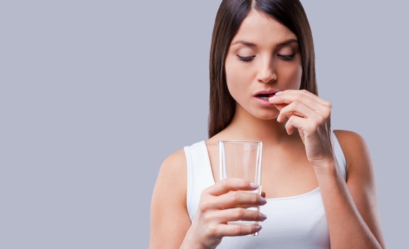 Девушка принимает таблетки