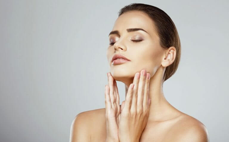 Девушка держит руки возле лица