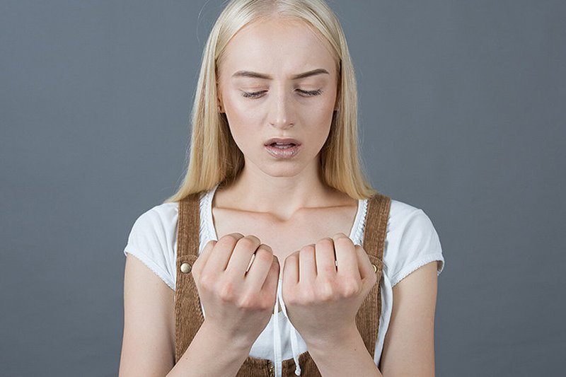 Девушка смотрит на свои ногти