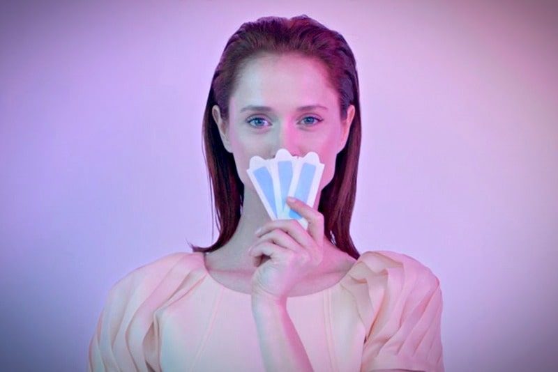 Девушка держит восковые полоски