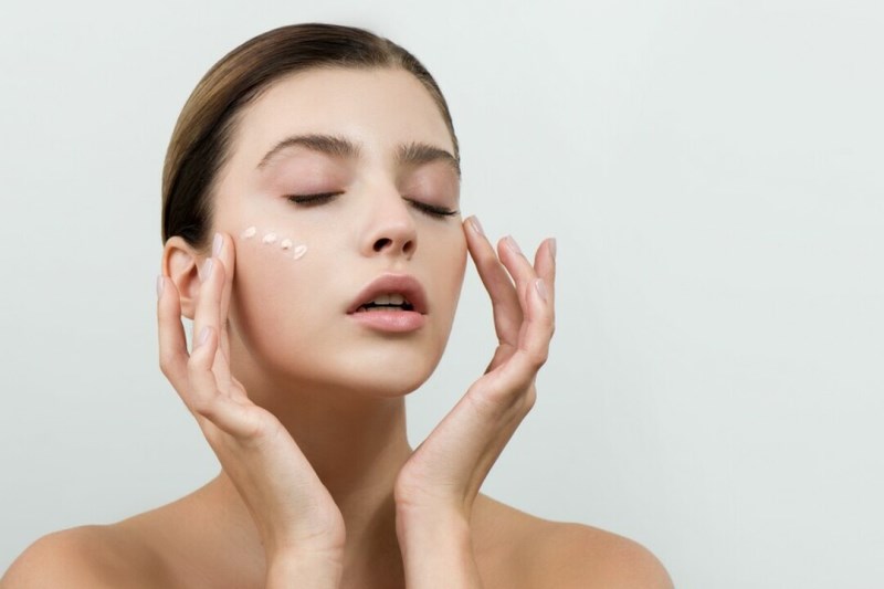 Девушка наносит крем