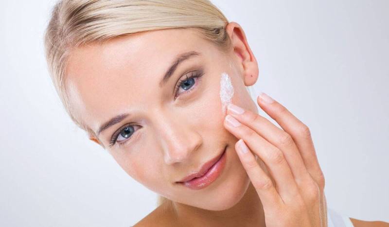 Девушка наносит крем