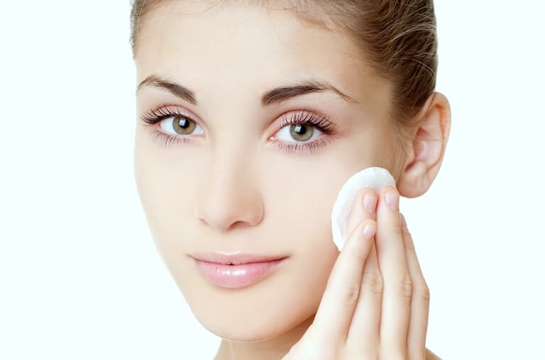 Девушка протирает лицо спонжем