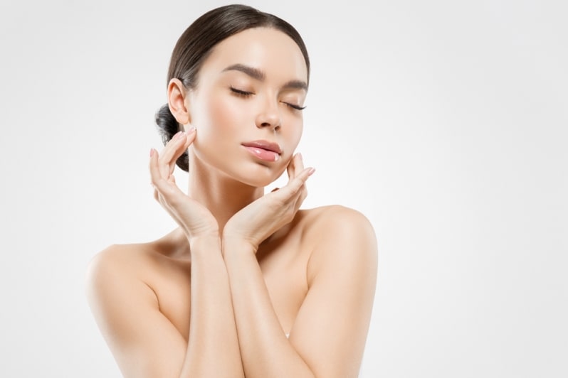 Девушка закрыла глаза и касается лица