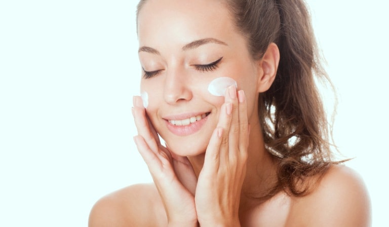 Девушка мажет лицо кремом