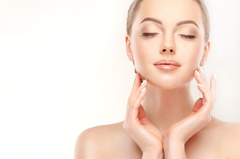 Девушка прикасается к лицу