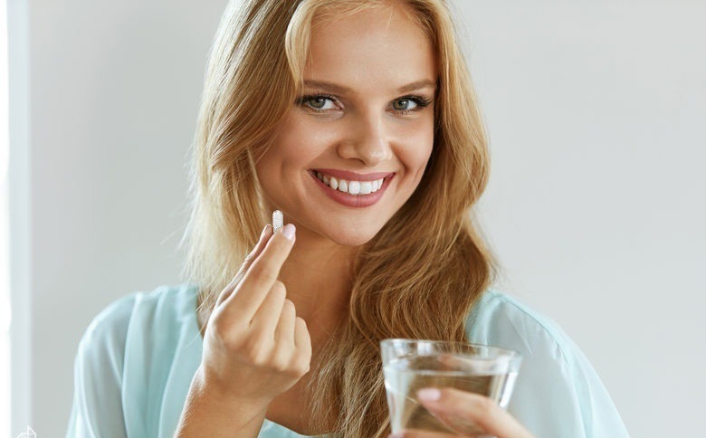 Девушка держит таблетку Эвалар