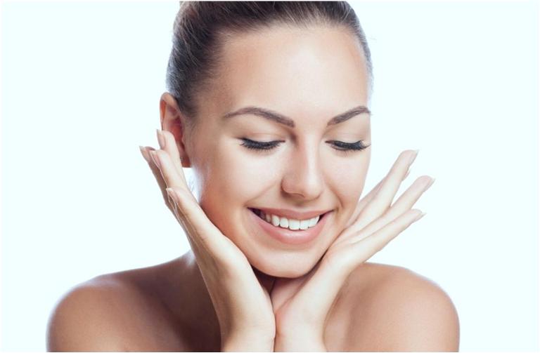 Девушка с улыбкой касается лица