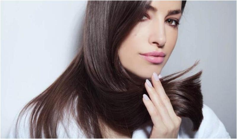 Женщина держит волосы