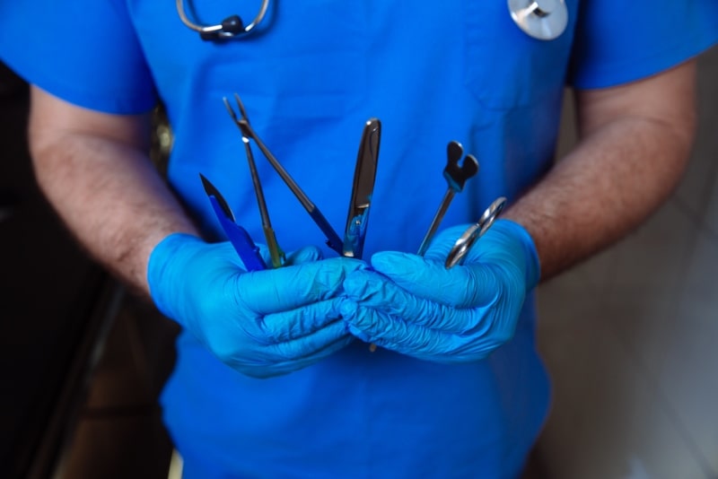 Доктор держит хирургические инструменты