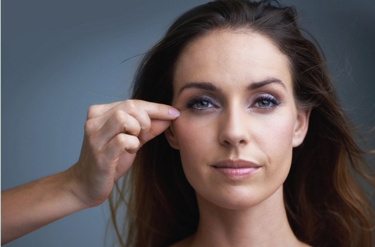 Женщина держит руку возле глаз