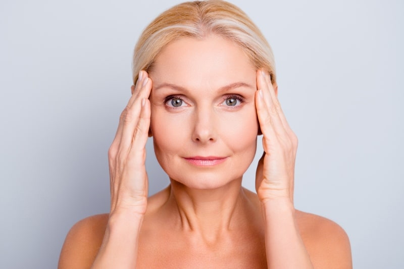 Женщина держит руки возле глаз