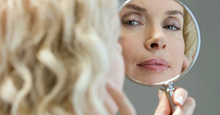 Женщина смотрит в зеркало