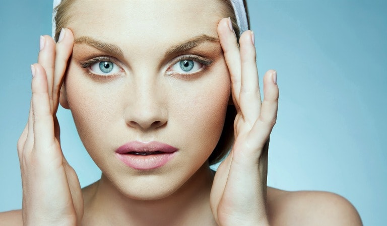 Девушка держит руки возле глаз