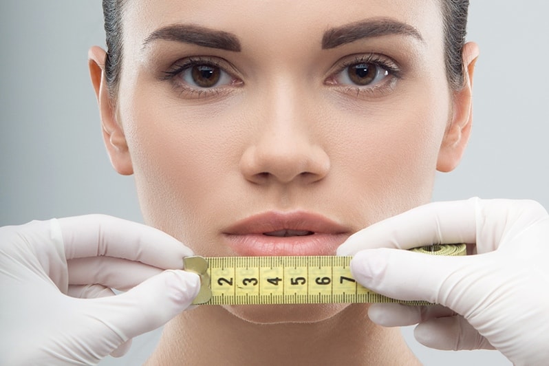 Сантиметровая лента возле лица