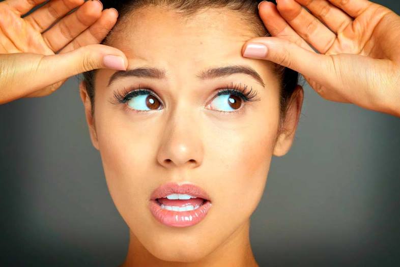Девушка держится за лоб