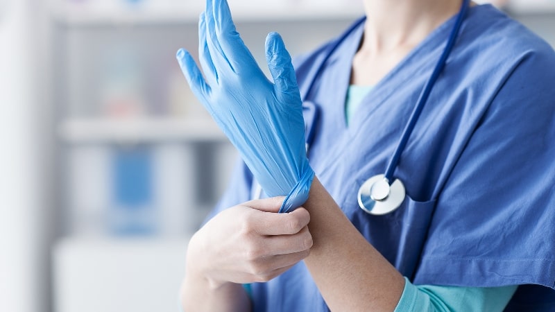 доктор надевает перчатку