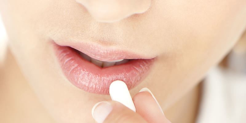 Таблетка с гиалуроном возле рта