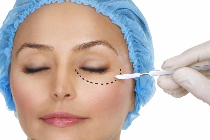 девушке скальпелем пунктир рисуют на лице