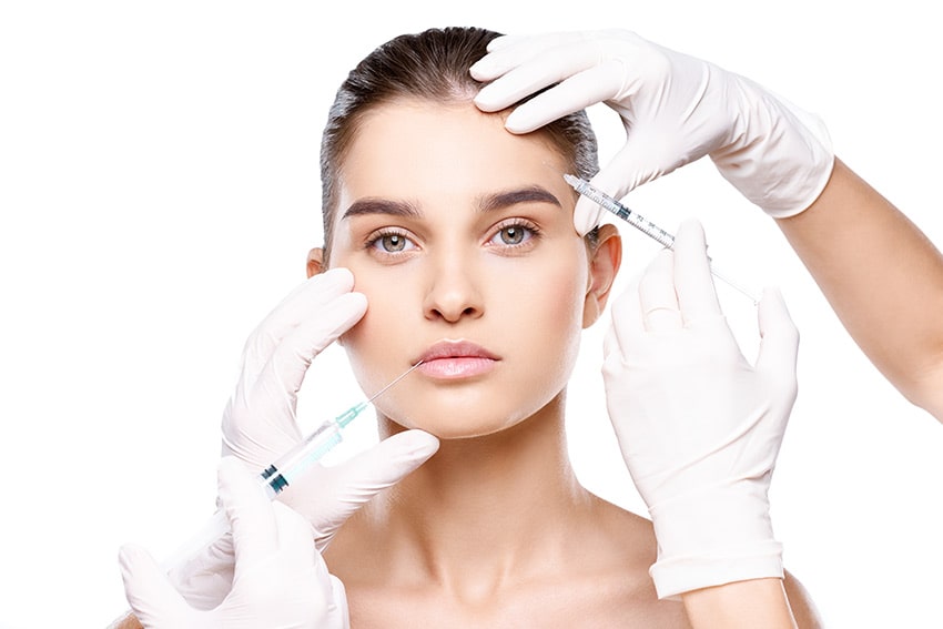 Руки врача держат укол возле лица