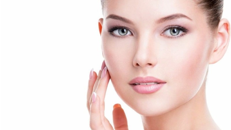 Девушка касается своей щеки