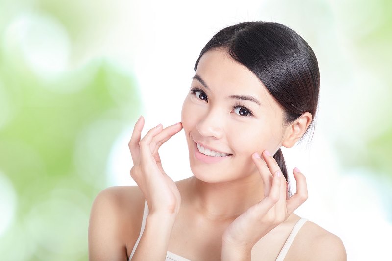 Девушка касается своего лица