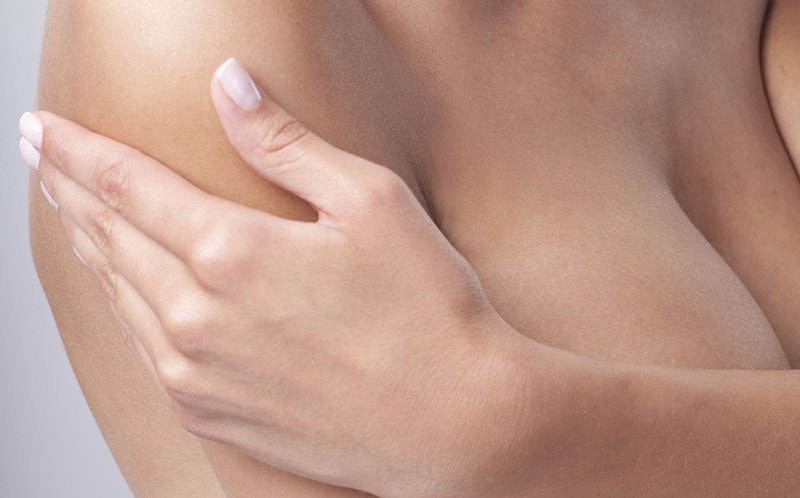 Женщина закрывает грудь