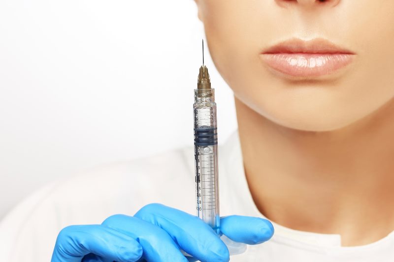 Доктор держит укол с филлером