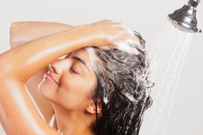 Девушка моет голову