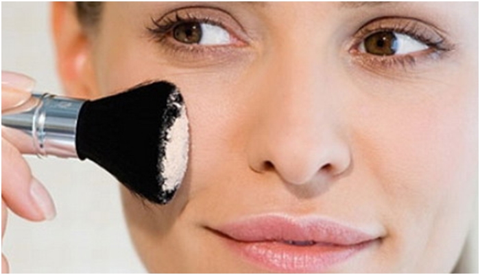 девушка красит румяна