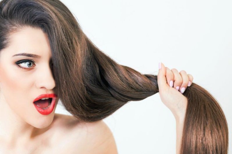 Девушка смотрит на волосы