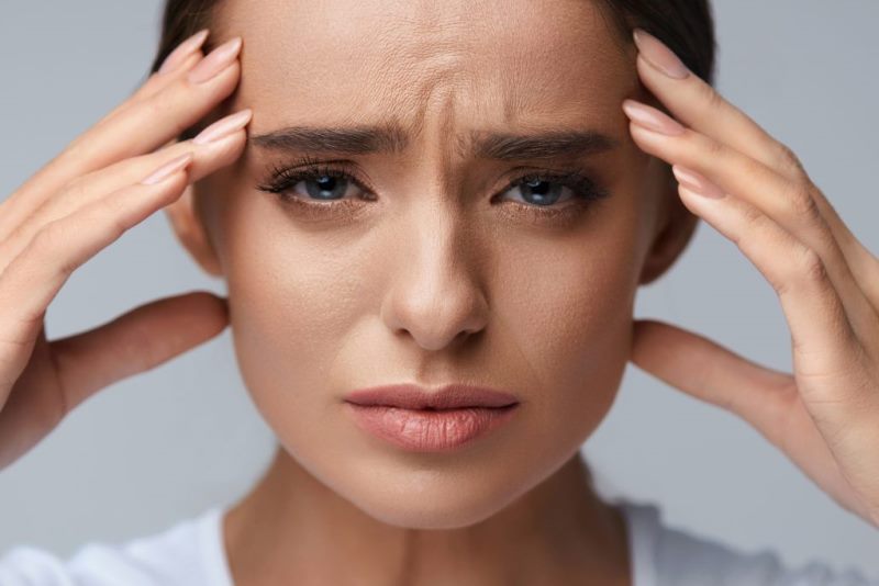 Женщина грустная держится за голову