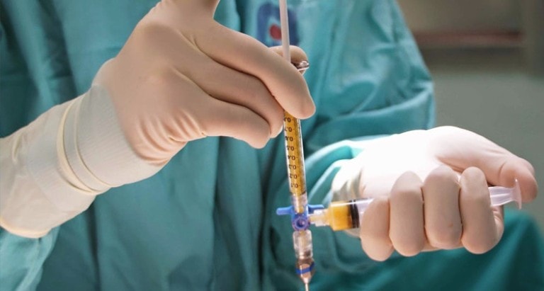 Доктор держит шприцы с жировыми клетками