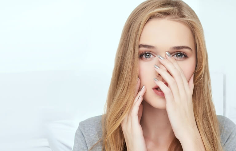 Девушка прикрывает нос
