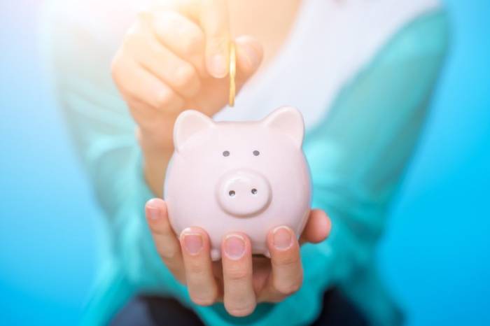 Девушка держит копилку