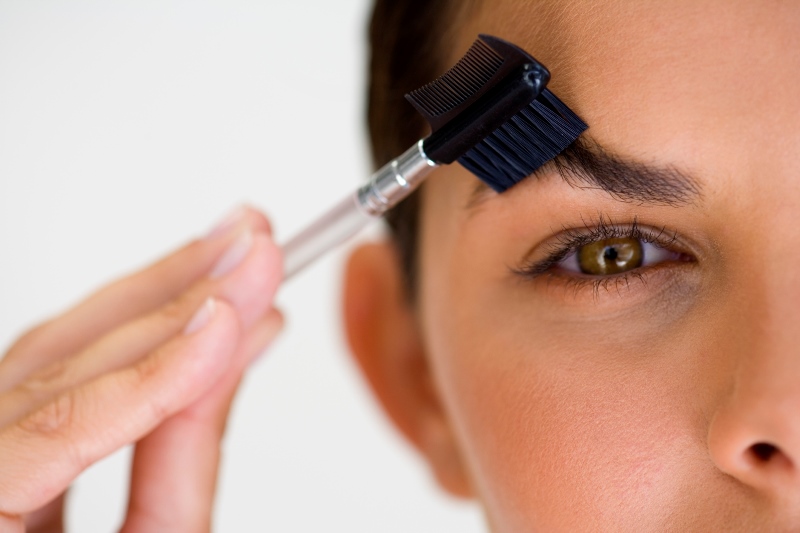 Девушка расчесывает брови