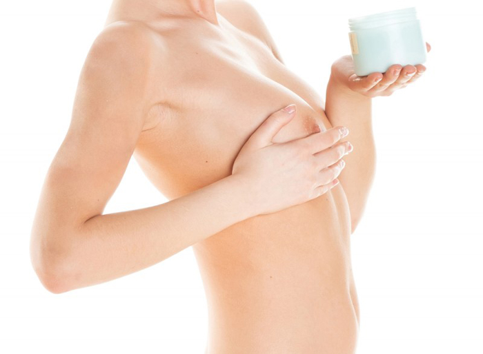девушка мажет грудь кремом