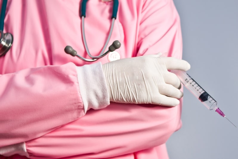 Доктор держит шприц