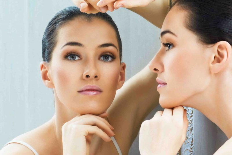 Девушка смотрит в зеркало